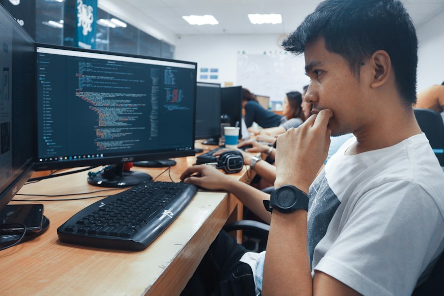 A student reading code on a monitor in a computer lab